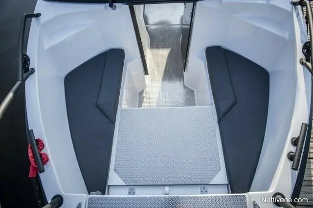 Spacious boat interior featuring dark upholstered seating, a non-slip floor, and a doorway leading to an exterior area.